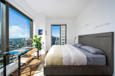 a bed sitting in a bedroom next to a window