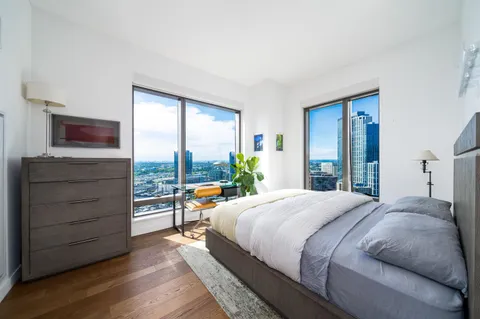 a bedroom with a bed and large windows