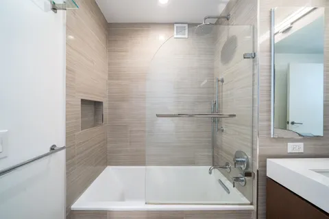 a white bath tub sitting next to a white sink and vanity