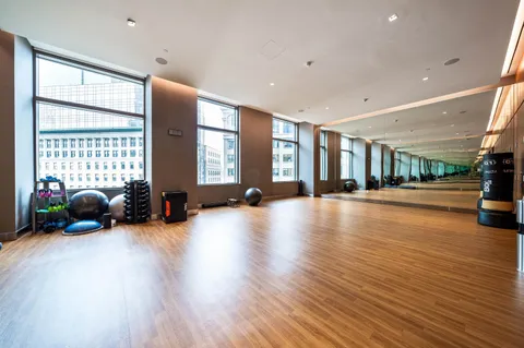 a view of a room with gym equipment and large windows