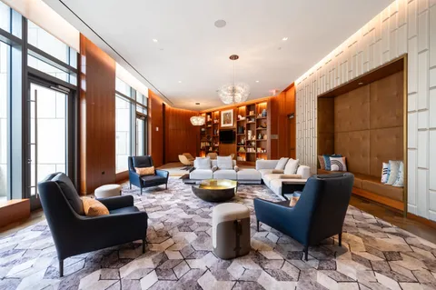 a living room with furniture and floor to ceiling windows