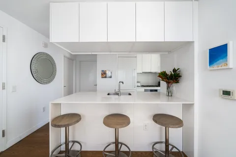a kitchen with a dining table chairs and a chandelier