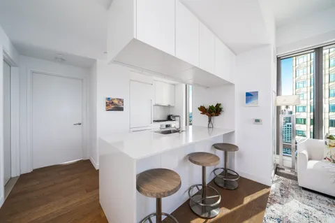 a kitchen with sink and view of living room