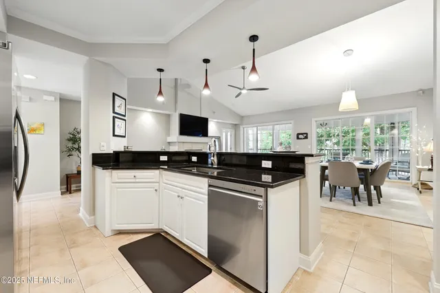 a kitchen with stainless steel appliances granite countertop a sink a stove and white cabinets
