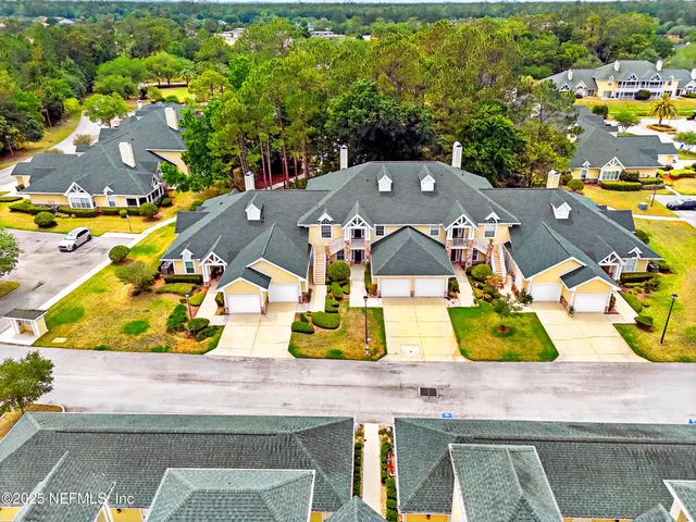 a white house that has a tree in front of it