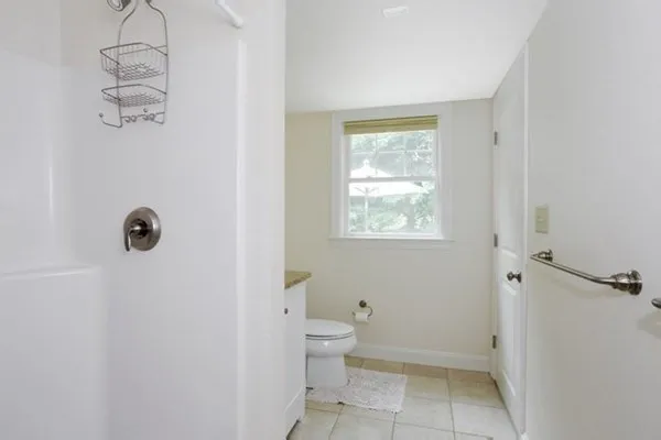 a bathroom with a granite countertop sink a toilet and shower