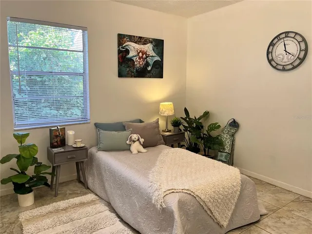 a bedroom with a bed mirror and window