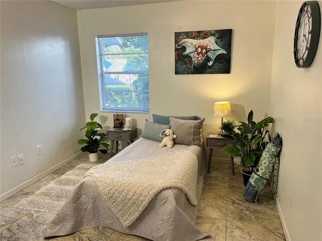 a bedroom with bed and paintings on the wall