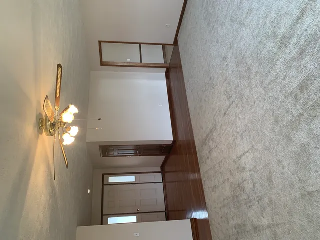 a view of a hallway with wooden floor and a window
