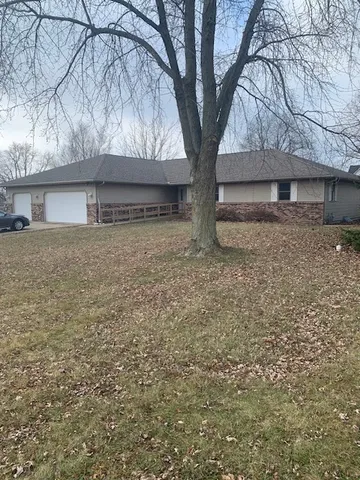 a white house that has a tree in front of it