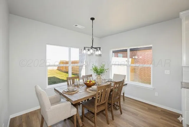 a view of a big room with wooden floor and windows