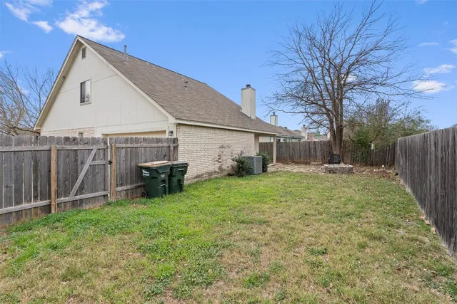 a view of a house with backyard and a tree