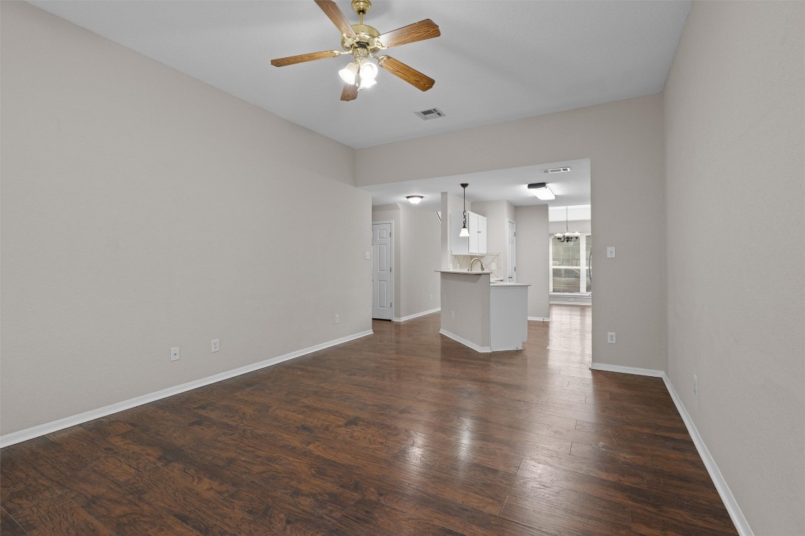 154 Meadowlark Circle Georgetown, TX 78626 - Photo 7 of 29 a view of an empty room with wooden floor and a ceiling fan