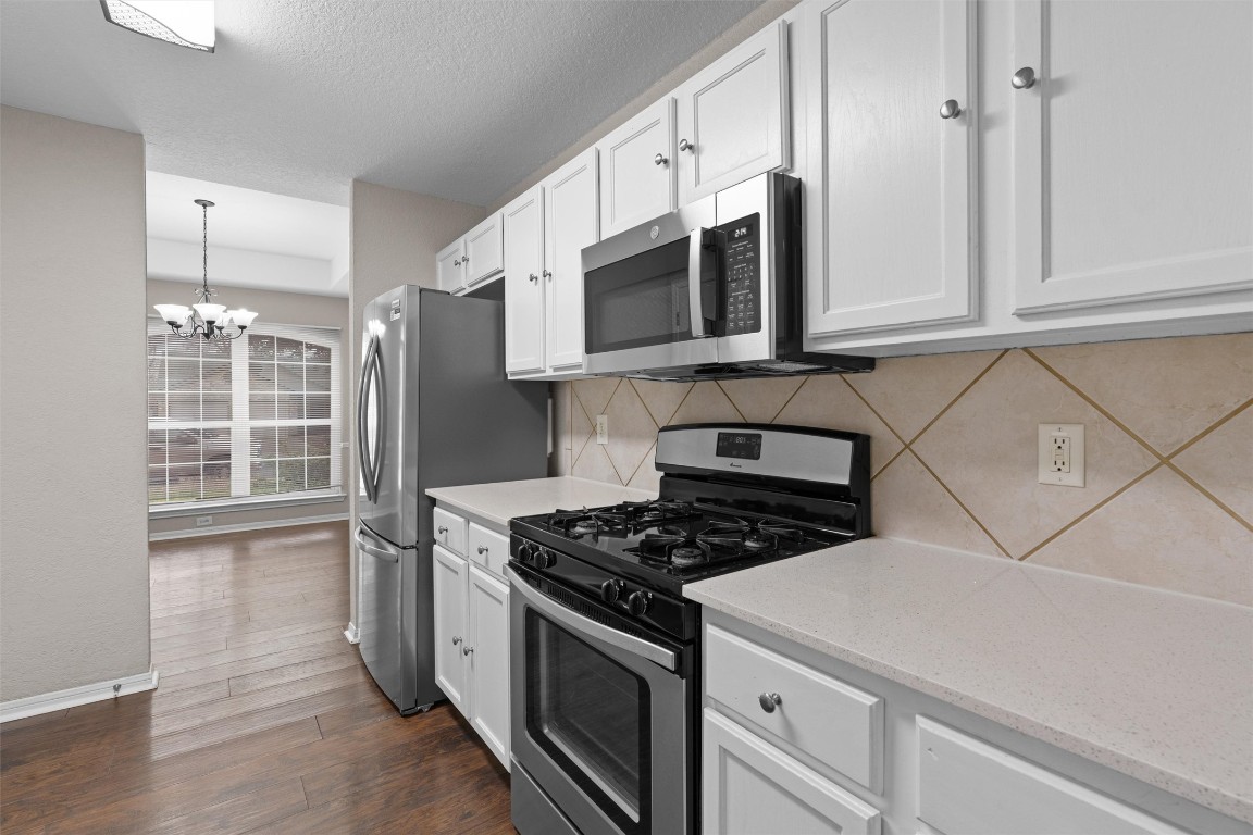154 Meadowlark Circle Georgetown, TX 78626 - Photo 9 of 29 a kitchen with stainless steel appliances granite countertop a sink stove and microwave