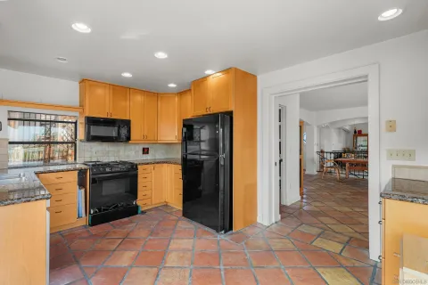 a kitchen with stainless steel appliances granite countertop a refrigerator and a stove top oven