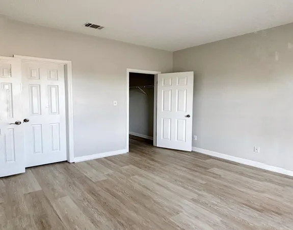 a view of an empty room with wooden floor