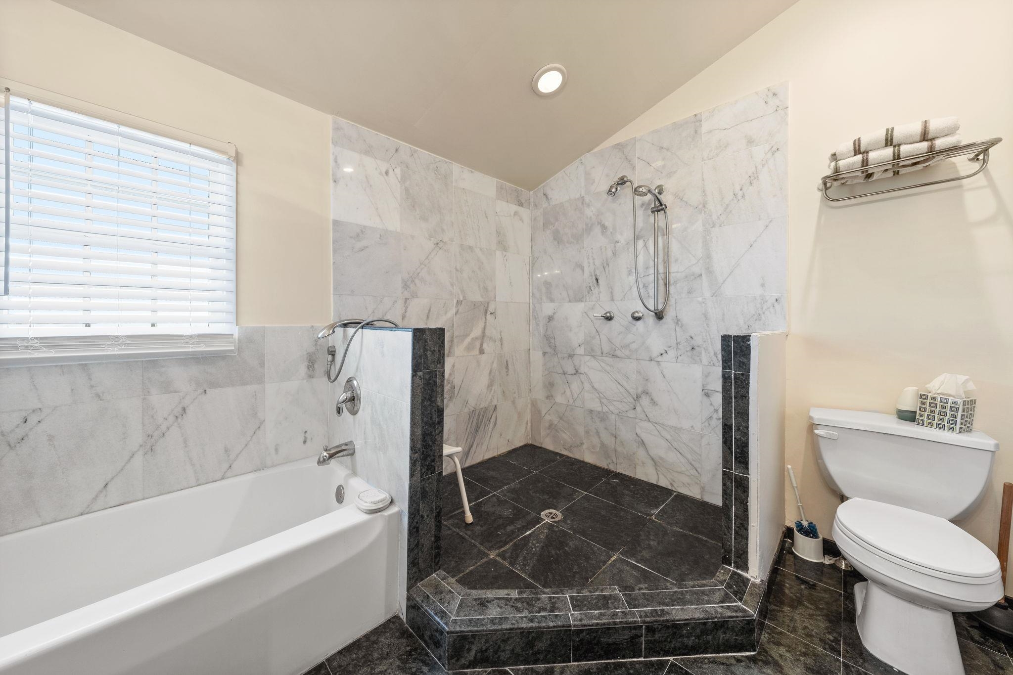 1 Leonards Avalon, NJ 08202 - Photo 15 of 22 a bathroom with a granite countertop bathtub shower sink mirror and toilet