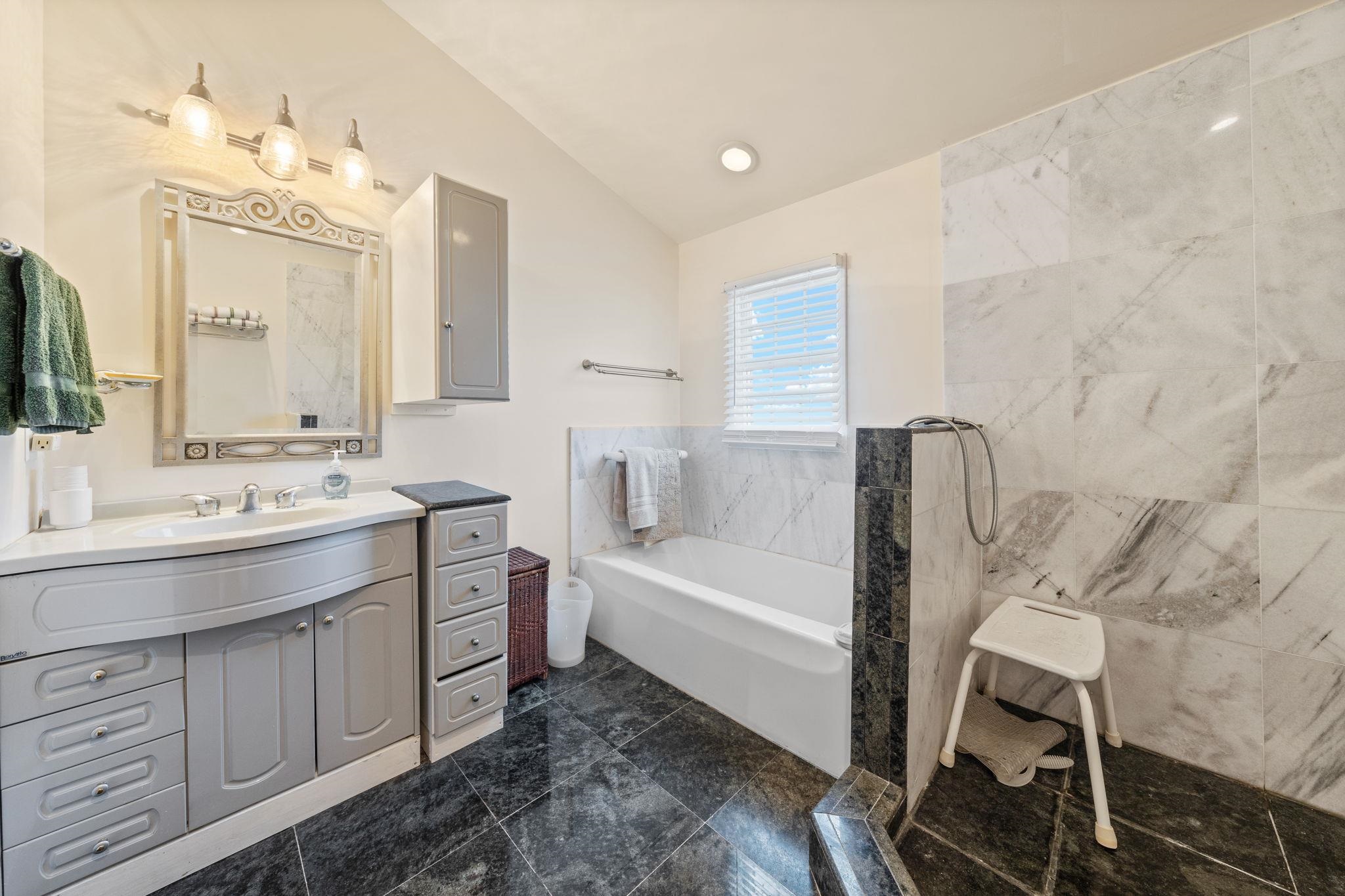 1 Leonards Avalon, NJ 08202 - Photo 16 of 22 a bathroom with a tub sink and mirror