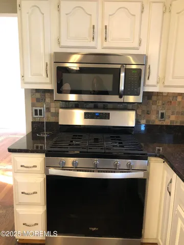 a stove top oven sitting inside of a kitchen