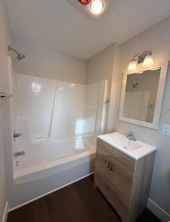 a bathroom with a sink a tub and a mirror
