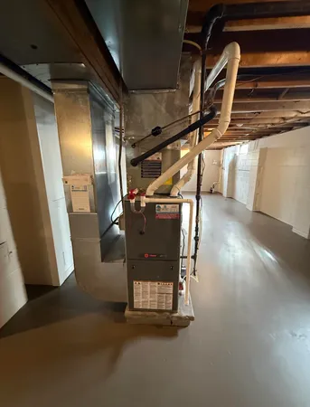 a water heater room with wooden floor