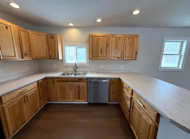 a kitchen with stainless steel appliances granite countertop a sink a stove a refrigerator and cabinets