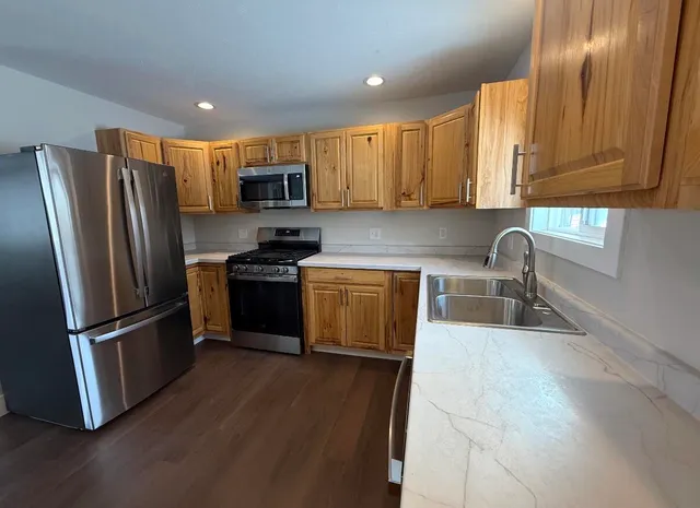 a kitchen with stainless steel appliances granite countertop a refrigerator sink and microwave