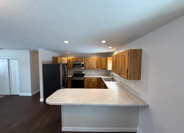 a kitchen with stainless steel appliances a refrigerator sink and wooden floor