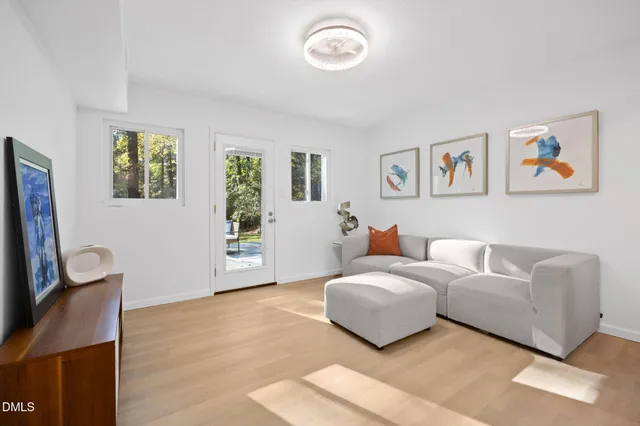 a living room with furniture and a refrigerator