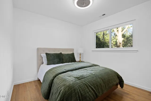 a living room with a bed furniture and a large window