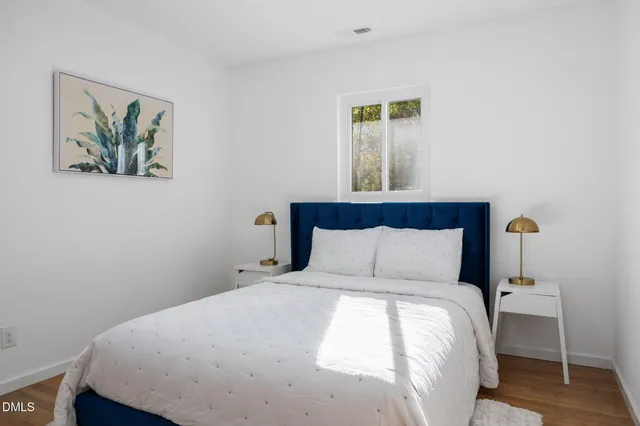 a bedroom with a bed and wooden floor