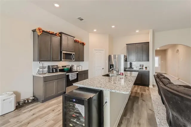 a kitchen with stainless steel appliances granite countertop a sink a stove a refrigerator and cabinets