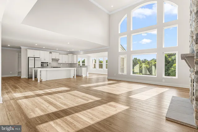 a view of a kitchen with kitchen island a sink wooden floor and a large window