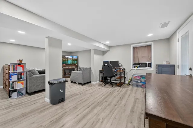 a spacious bedroom with a bed and a dresser with wooden floor