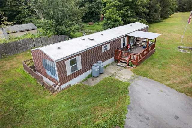 a view of a white house with large windows and a small yard
