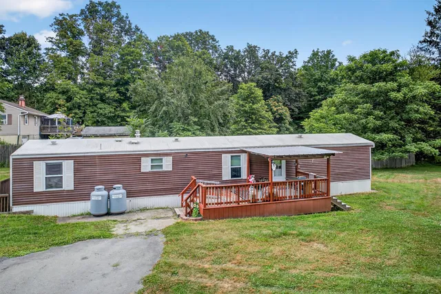 a view of a house with a yard and sitting area