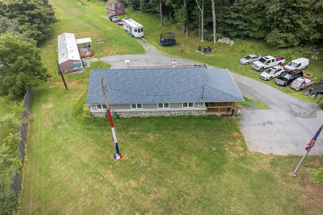 an aerial view of a house with garden space and a patio