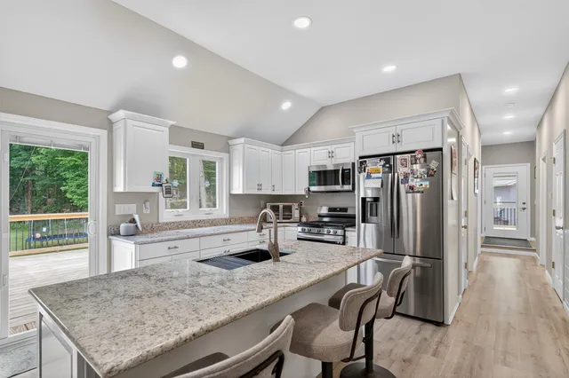 a kitchen with stainless steel appliances granite countertop a stove refrigerator and cabinets