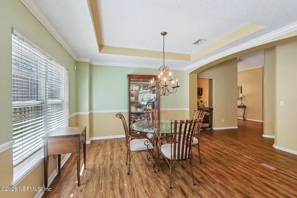 a view of an empty room and kitchen with furniture wooden floor and window