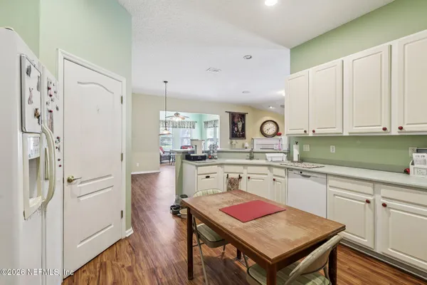 a kitchen with white cabinets and white appliances