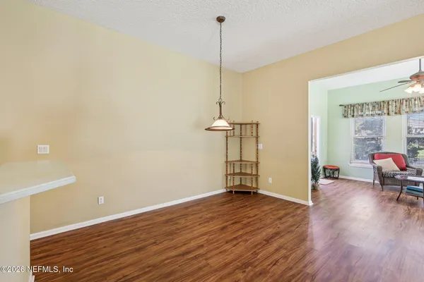 a view of a livingroom with furniture a fireplace wooden floor and a chandelier