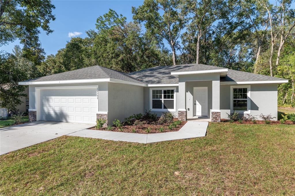 19230 Southwest 97th Street Dunnellon, FL 34432 - Photo 2 of 30 a front view of a house with a yard and porch