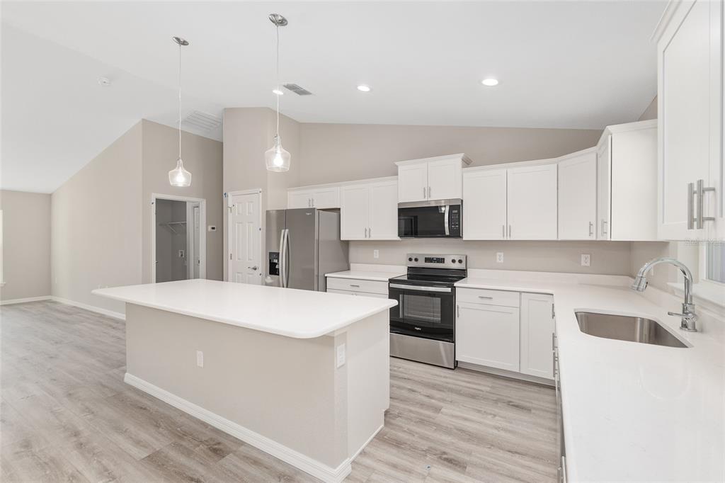 19230 Southwest 97th Street Dunnellon, FL 34432 - Photo 7 of 30 a kitchen with stainless steel appliances a white stove top oven sink and cabinets