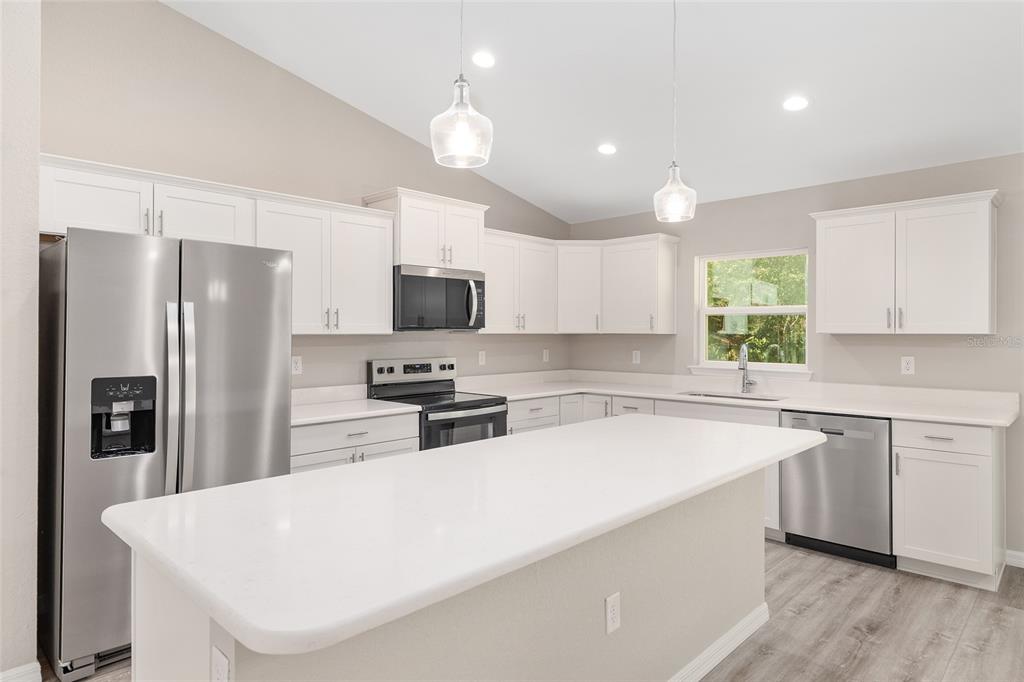19230 Southwest 97th Street Dunnellon, FL 34432 - Photo 8 of 30 a kitchen with stainless steel appliances a refrigerator sink and microwave