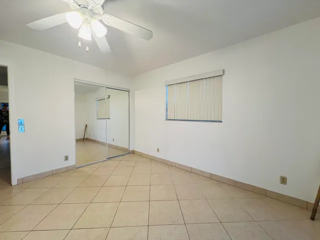 an empty room with a ceiling fan and a window