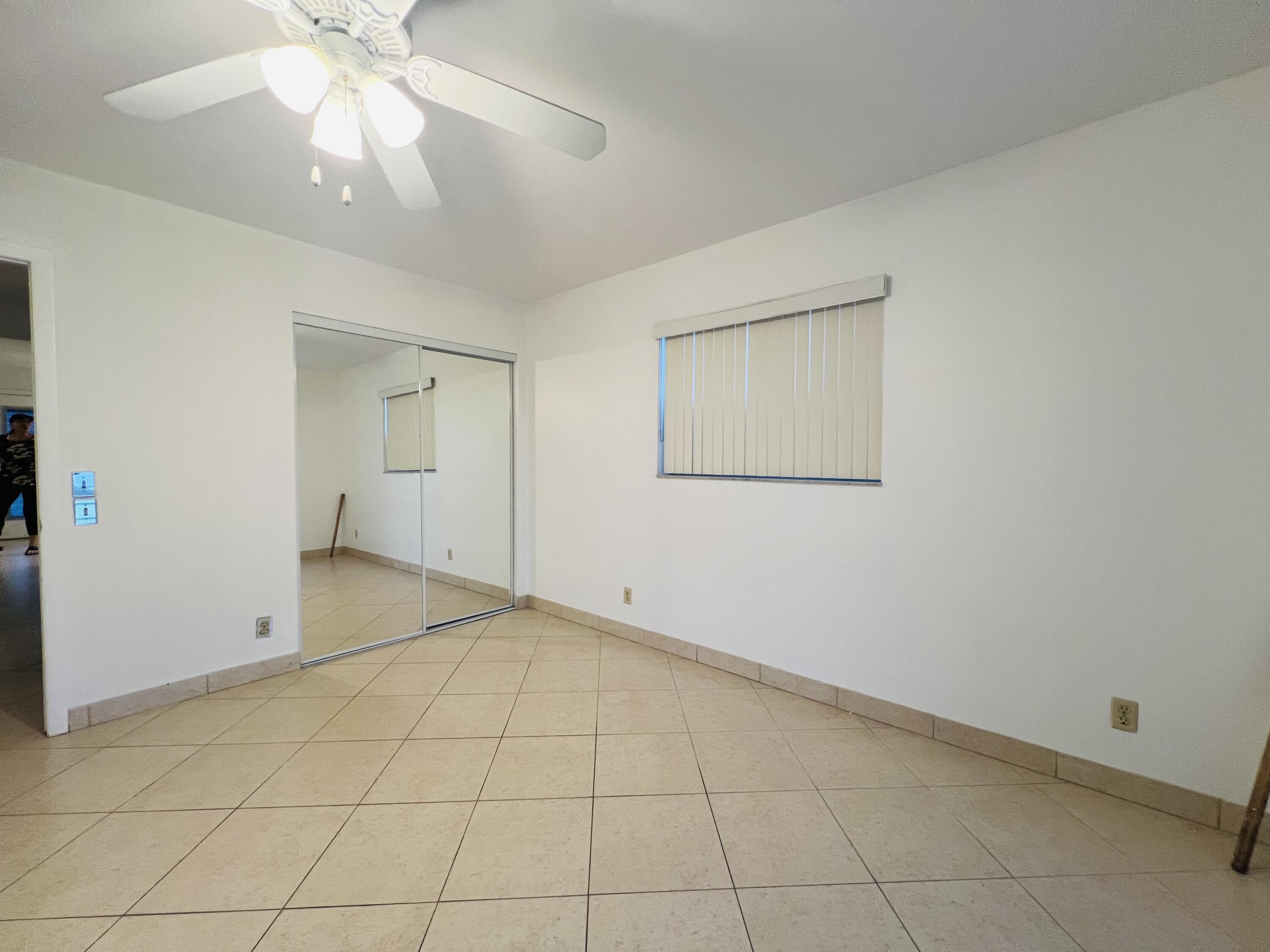 82 Normandy B Delray Beach, FL 33484 - Photo 12 of 31 an empty room with a ceiling fan and a window