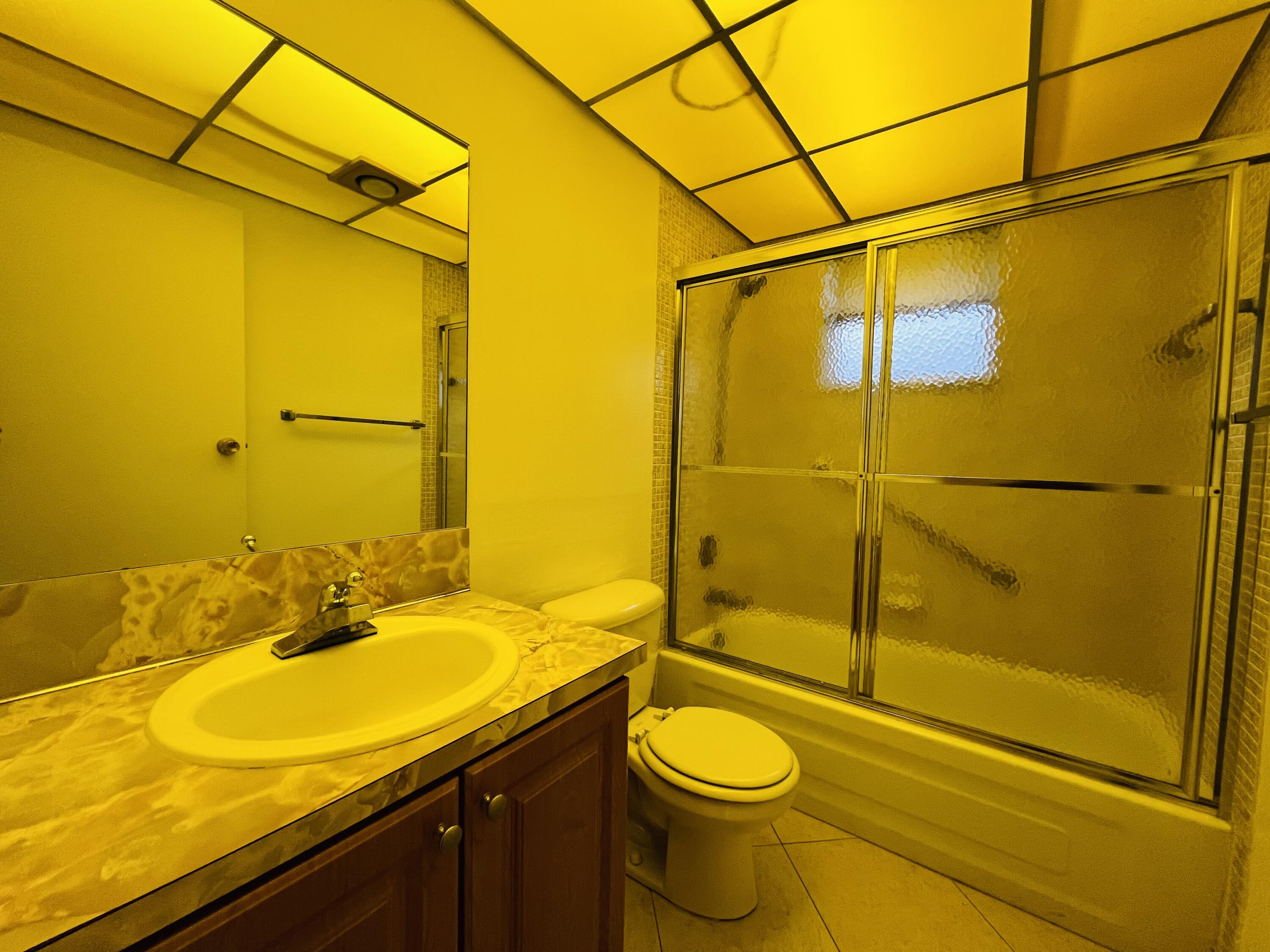 82 Normandy B Delray Beach, FL 33484 - Photo 13 of 31 a bathroom with a sink and a mirror