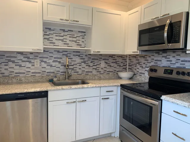 a kitchen with stainless steel appliances granite countertop a sink stove and microwave