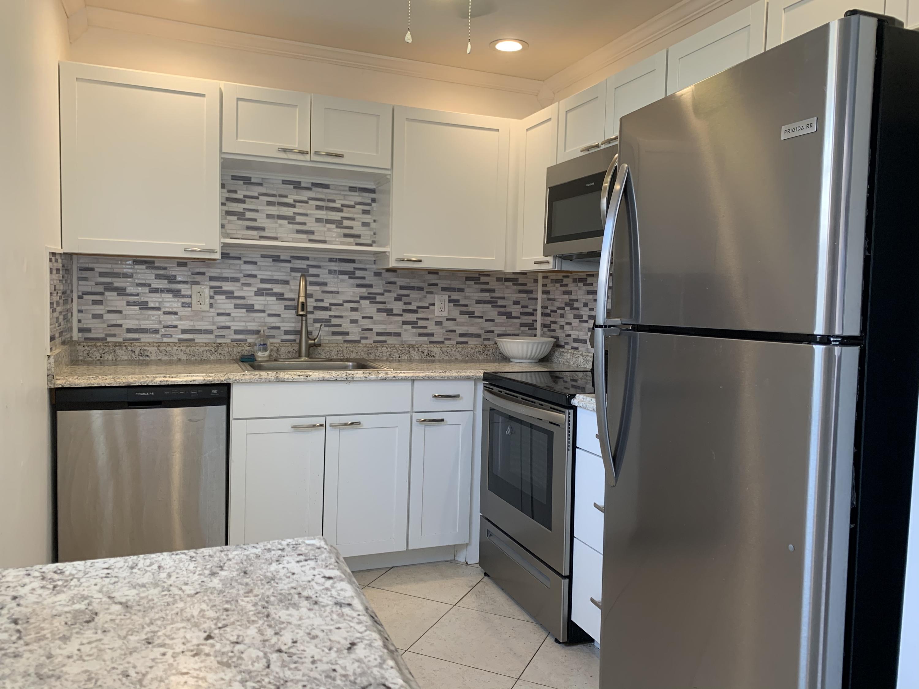 82 Normandy B Delray Beach, FL 33484 - Photo 20 of 31 a kitchen with stainless steel appliances granite countertop a refrigerator and a sink