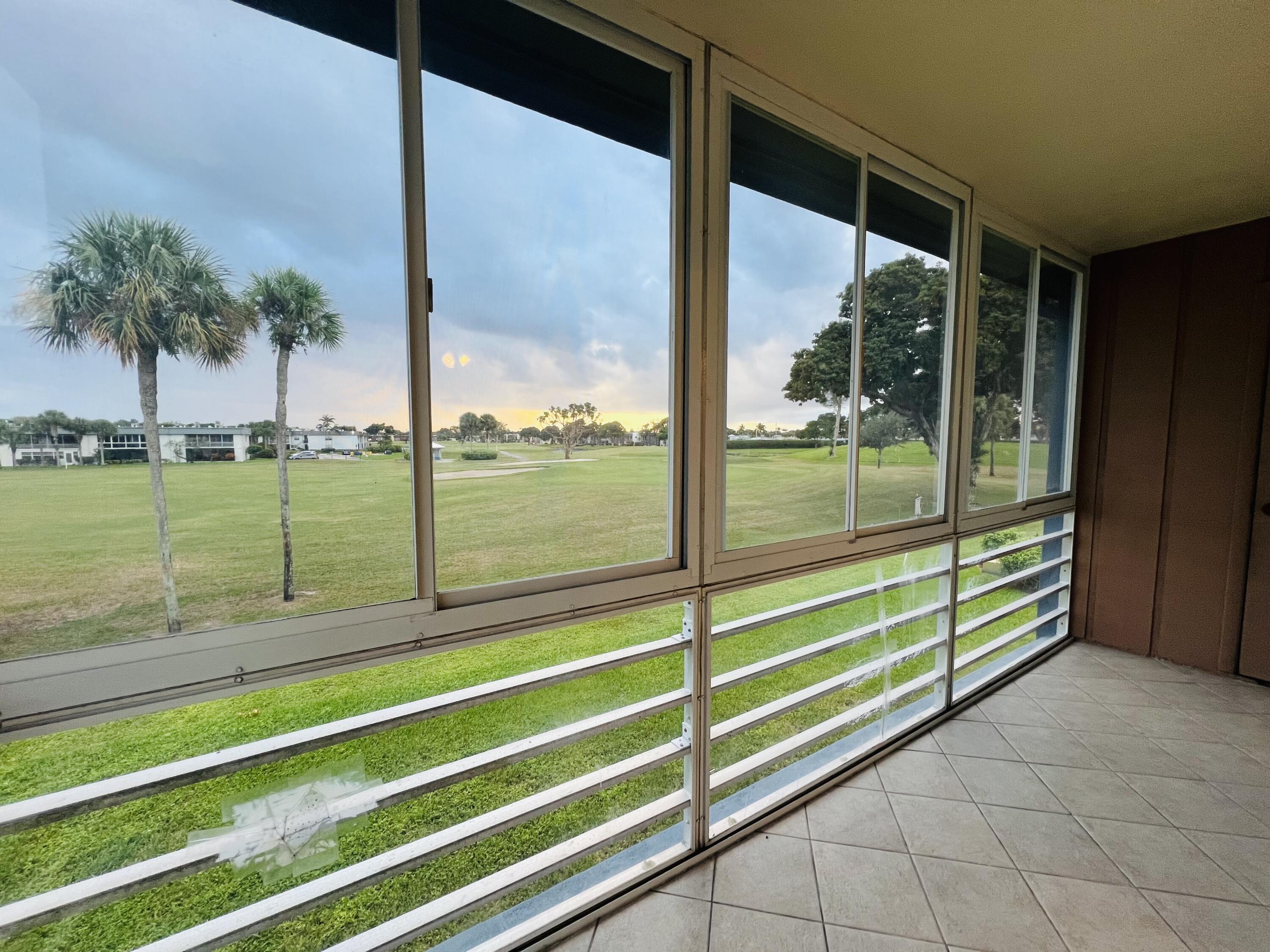 82 Normandy B Delray Beach, FL 33484 - Photo 2 of 31 a view of a room with a large window and wooden floor